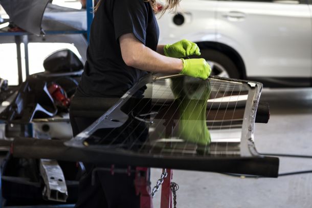 Auto Glass Repair Technician Working On Windshield Replacement