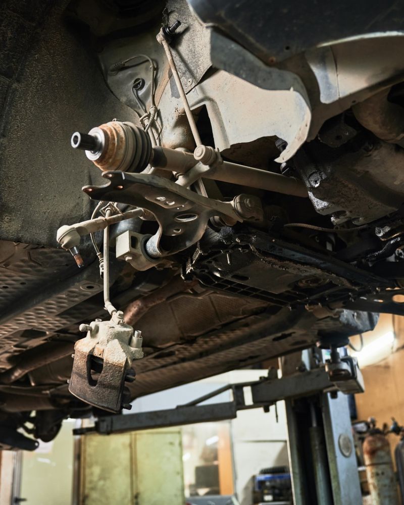 Suspension Repair Underneath Vehicle Lifted In Garage Workshop