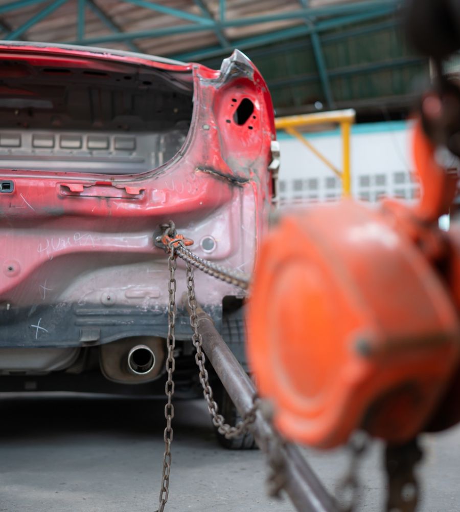 Car Frame Repair Service In Workshop With Chains And Tools