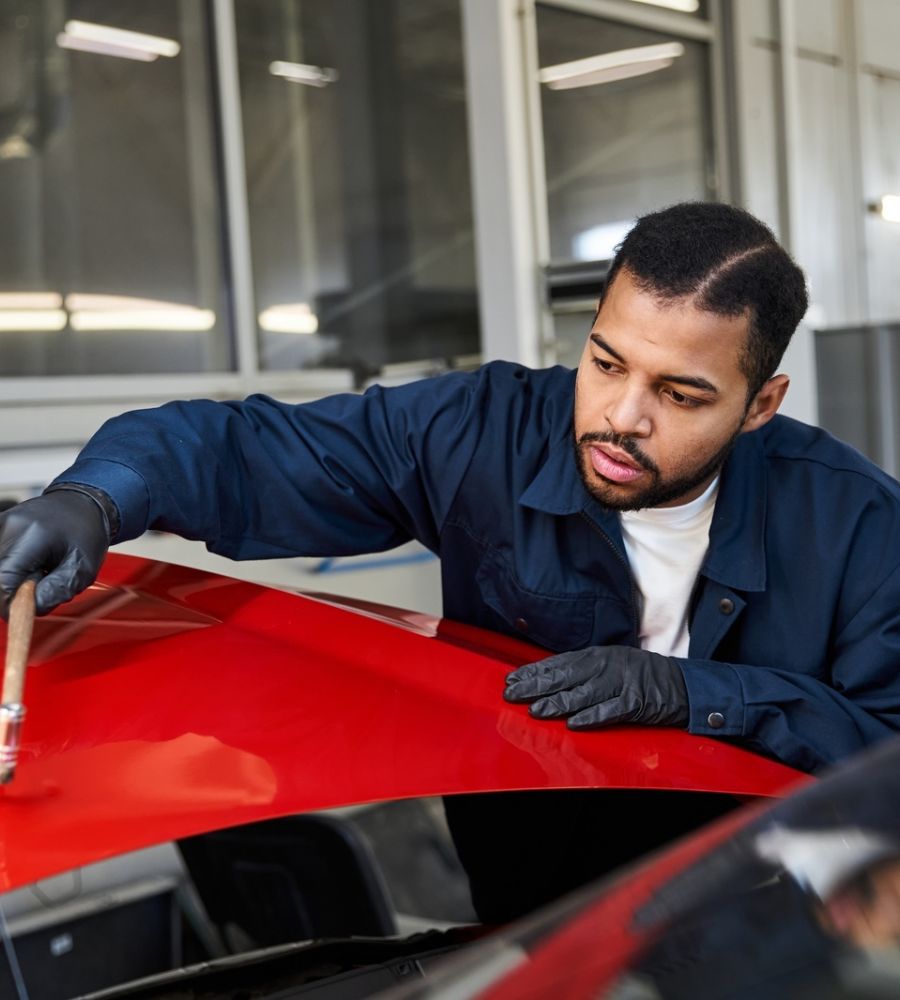 Autobody Repair Technician Painting Red Car Hood.jpg
