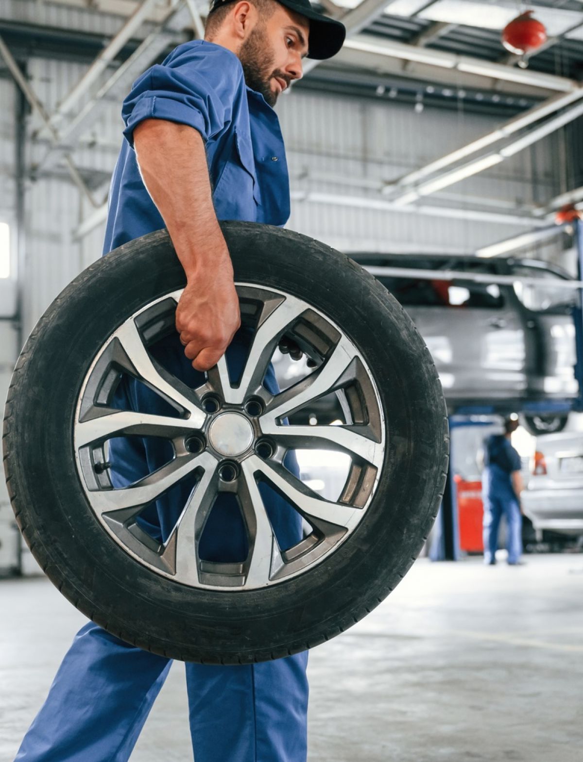 Manassas Wheel Repair Service Technician Carrying Wheel In Shop