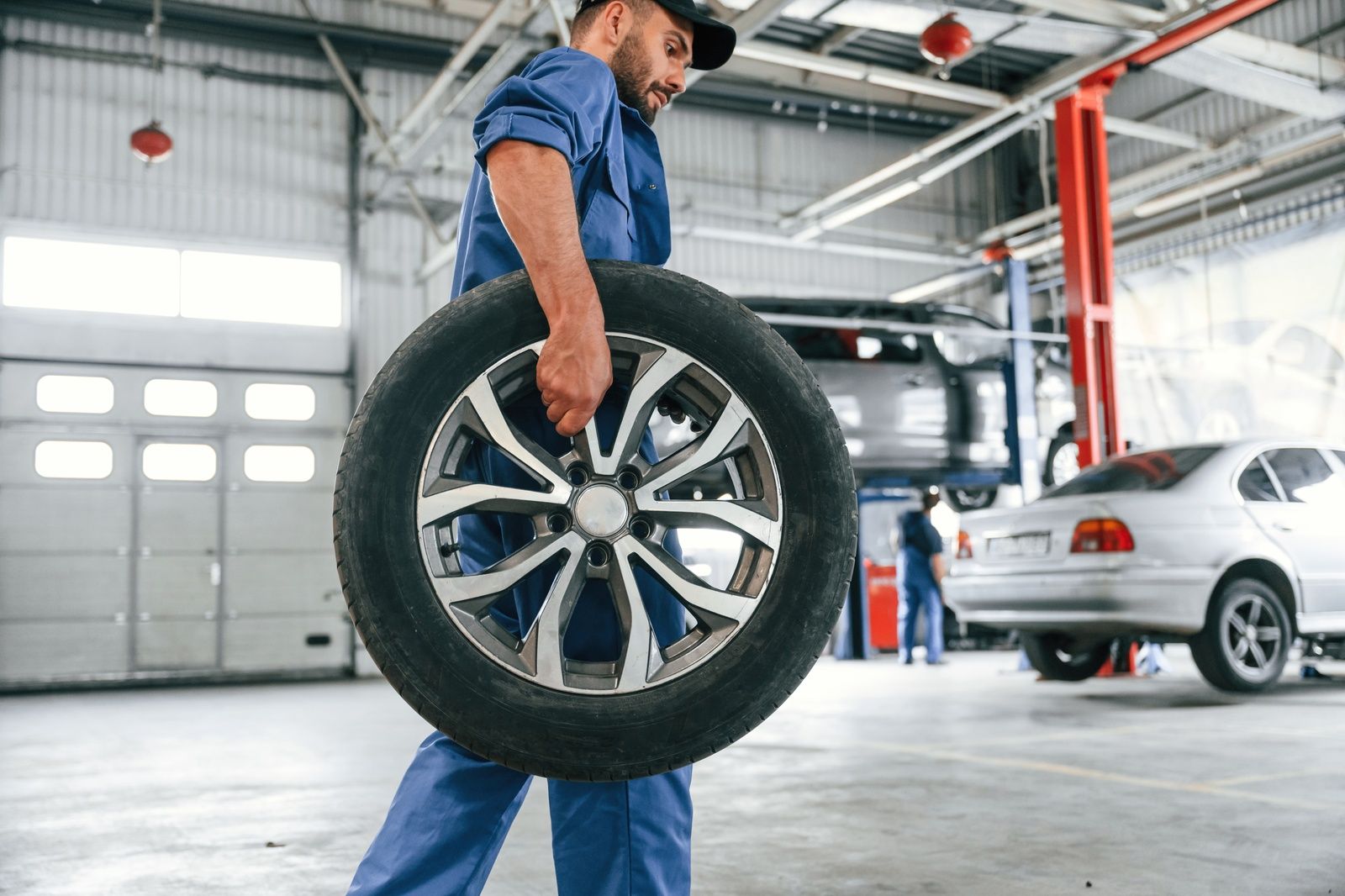 Bristow Wheel Repair Service Technician Carrying Wheel In Shop