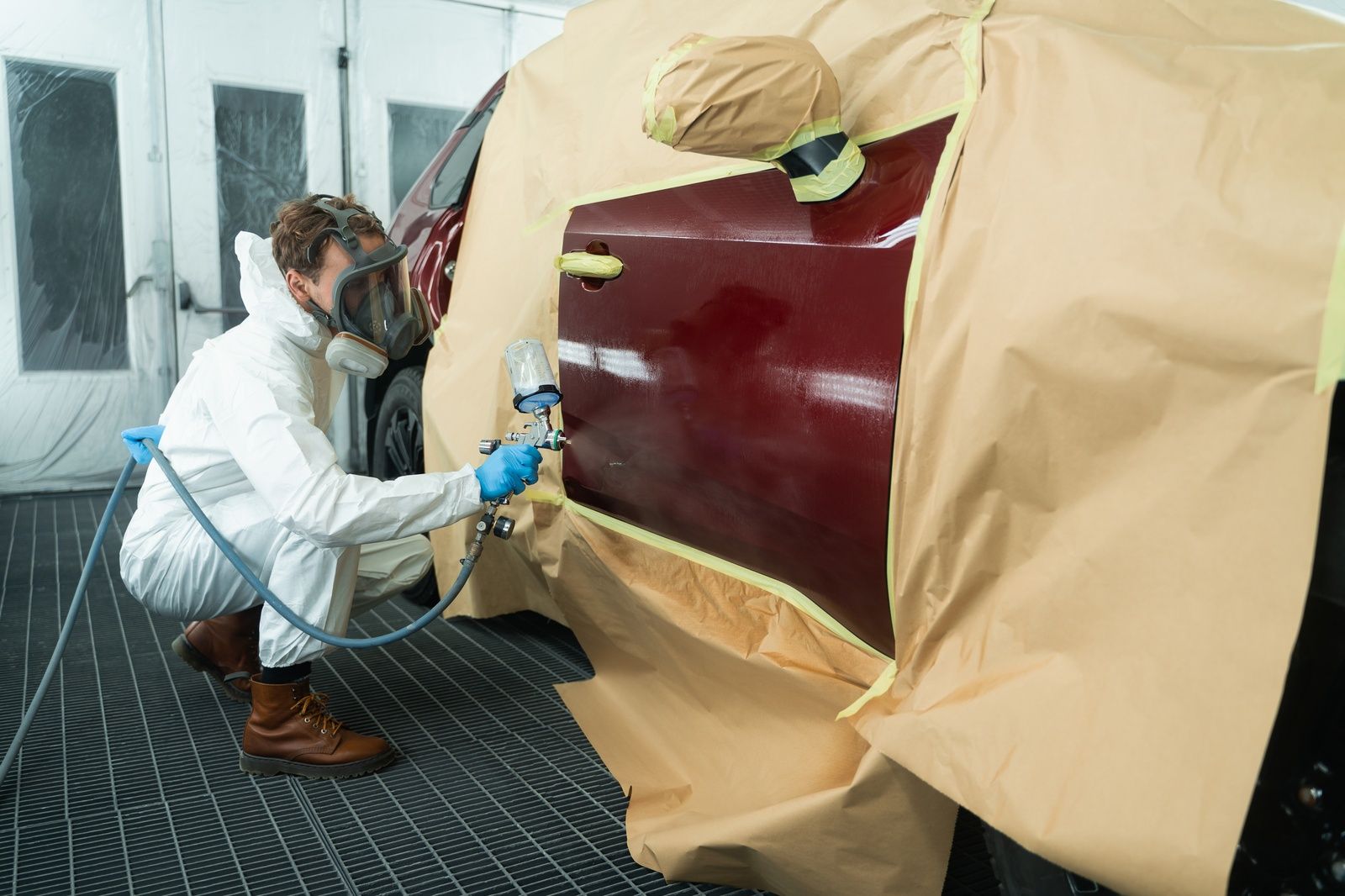 Auto Painting Service Technician Spraying Red Car Door