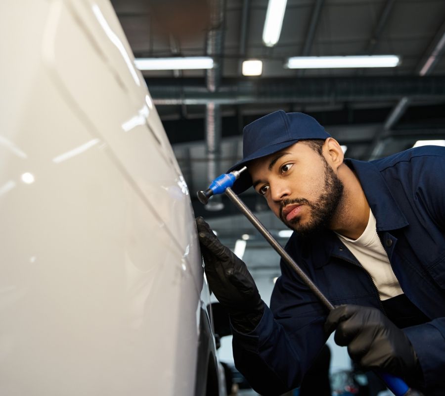 Auto Body Repair Technician Inspecting Car Panel Damage