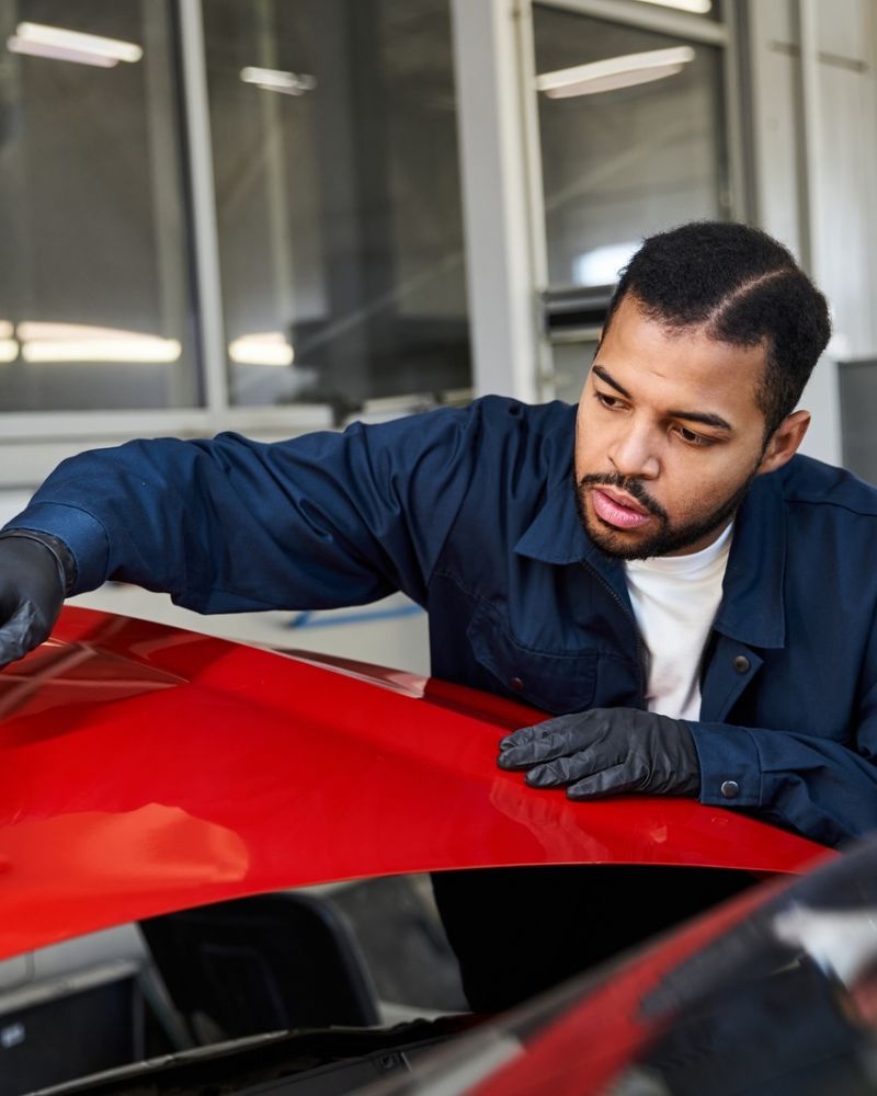 Autobody Repair Technician Painting Red Car Hood.jpg